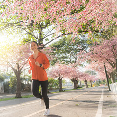 Asian woman exercise in the morning She is running at Sakura Park.