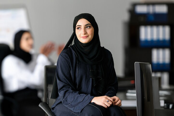 Sitting Arab Emirati woman at office with Arabic colleagues, around looking far away. Arabic...