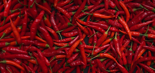 Naklejka premium A vibrant texture of fresh red chili peppers creates a spicy background. Hot peppers.
