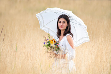 Pretty woman with umbrella and flowers