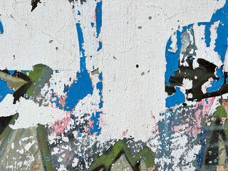 Grungy, distressed layers of peeling paper on a wall in Mexico