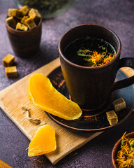 A cup of tea with dried fruits and herbs, cane sugar, dark composition. Tea drinking..