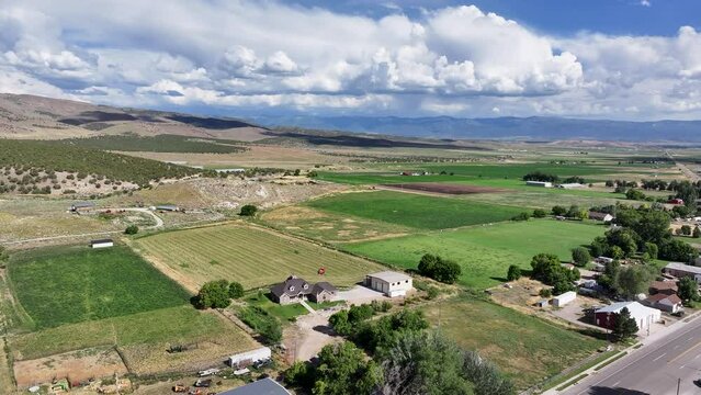 Aerial rural city farms agriculture mountains 2 . Farming community agricultural economy. Spring summer weather mountain valley green agriculture field. Homes, barns and buildings.