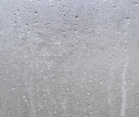Drops of frozen water on the window glass on a cold winter day