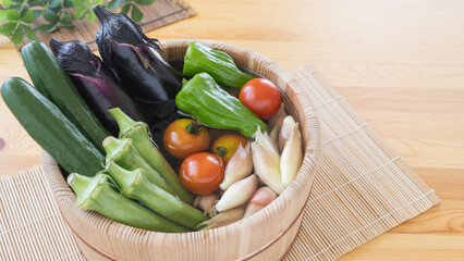 夏野菜イメージ・木桶に水を入れて野菜をつける｜きゅうり・なす・ピーマン・ミニトマト・オクラ・ミョウガ © aomas