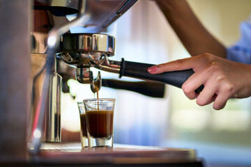Barista make a coffee espresso shot by coffee machine in cafe.