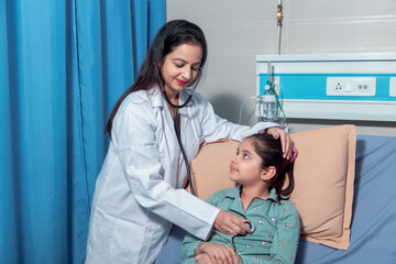 Indian female doctor check up to little girl at hospital