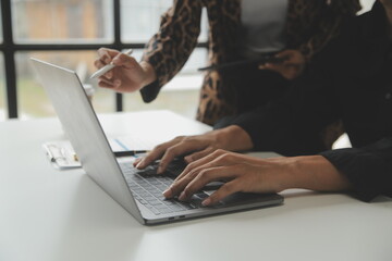 Entrepreneur Asian businessman and businesswoman discussing new business project in tablet in modern Meeting In Modern Office, Asian business casual concept.