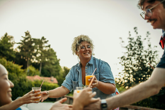 The male and female hosts serve juices and drinks to his friends around the pool.