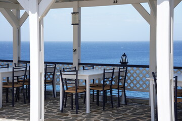 The cozy veranda of a restaurant and  turquoise colored bay of Mediterranean sea, Rhodes island, Greece
