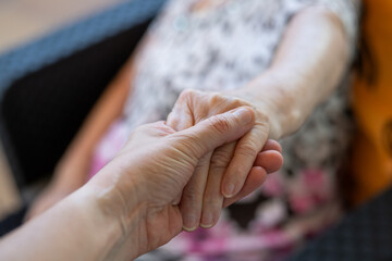 Senior And Young Holding Hands. Care For The Elderly Concept.Daughter Consoling Her Mother By...