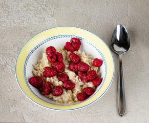 oatmeal with raspberries on a textured background, healthy breakfast