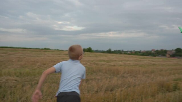 a boy plays with an airplane in nature,a boy launches a toy plane into the sky on a field