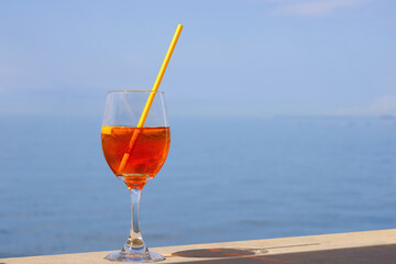 Refreshing aperitif Aperol spritz on a background of blue sea.