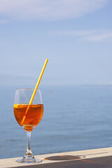 Refreshing aperitif Aperol spritz on a background of blue sea.