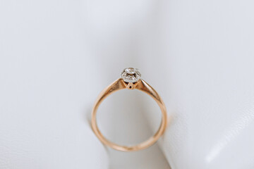 Golden women's ring with a precious stone on a white background