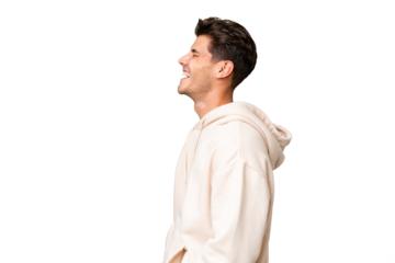 Young caucasian handsome man over isolated background laughing in lateral position