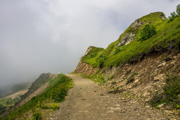 Beautiful panoramic landscape - mountain slopes and trekking trails with a large dramatic cloud and a space to copy in Krasnaya Polyana sochi russia