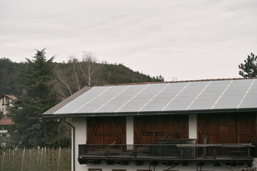 Obraz premium House roof with solar panels installed. The integration of solar technology into the roof tiles highlights the innovative approach to energy generation, offering an alternative source of electricity.