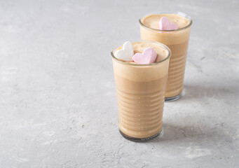 Two glasses of cocoa and marshmallow shaped hearts on a light background. Coffee with ice cream..
