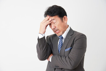 頭痛がするミドルエイジのビジネスマン　白背景