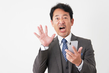 スマートフォンを持って驚くミドルエイジのビジネスマン　白背景