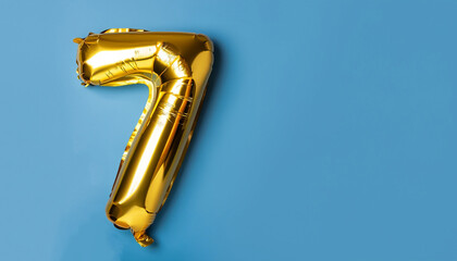 Banner with number 7 golden balloon with copy space. Seven years anniversary celebration concept on...