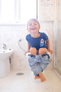 Cute child, boy, sitting on the toilet