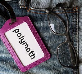 Purple ID card and reading glasses in jeans pocket written POLYMATH - someone with extensive...