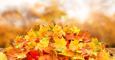 Wooden table with orange leaves autumn background