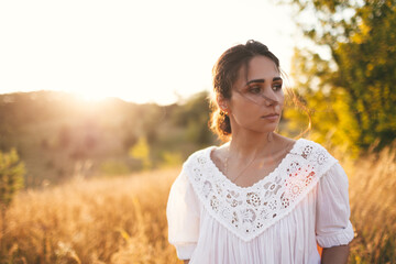 Young woman on field under sunset light