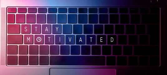 Flat lay photo of close up laptop keyboard with stay motivated quote on buttons. Inspirational...