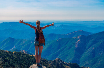 travel, tourism, adventure concept- Woman on top of mountain