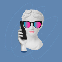 Young confident woman in sunglasses headed by antique statue head talking on the mobile phone isolated on blue color background. Trendy collage in magazine style. Contemporary art. Modern design