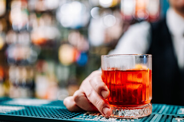 man bartender hand making negroni cocktail
