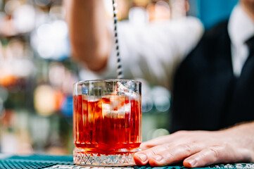 man bartender hand making negroni cocktail