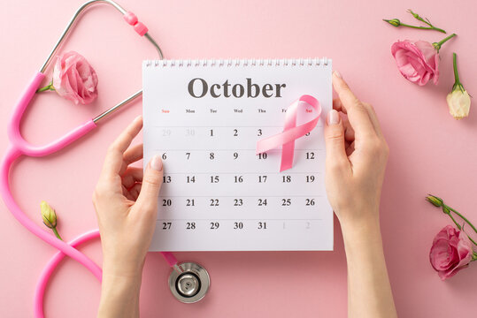 Show your support during International Breast Cancer Awareness Month. Top view picture with hands, calendar, and pink ribbon on pastel pink isolated background, suitable for text or advertising