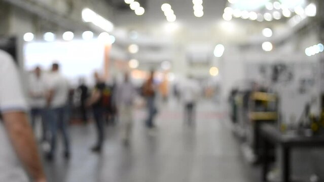 Large high building premises with people walking inside. Expo exhibition presentation expo center. Blurred background.