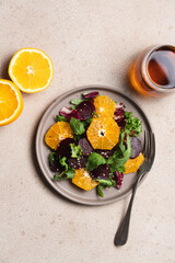 Seasonal vitamin salad orange beetroot and arugula in plate on light background. Diet, healthy eating concept
