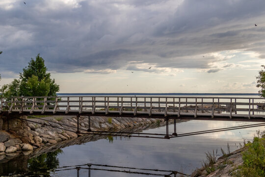 abandoned bridge over a river, image shows a bridge in a abandoned soviet facility on the coast of Parispea, lahemaa national park , Estonia with a calm sea and sunset. August 2023