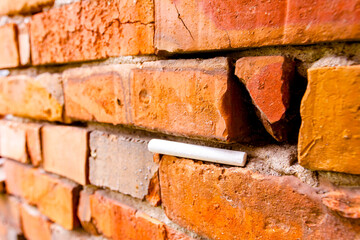 White chalk placed on old red brick wall