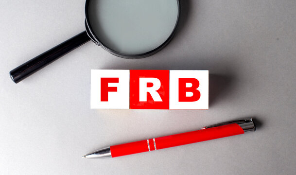 FRB word on wooden cubes with pen and magnifier