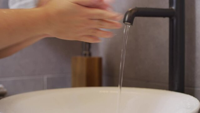person washing hands in sink