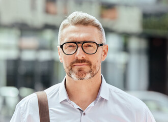 Mature business man, city and portrait with glasses, bag and ready for walk, travel and outdoor in metro. Entrepreneur, CEO or manager in road, traffic or sidewalk with pride on serious face in Milan - Powered by Adobe