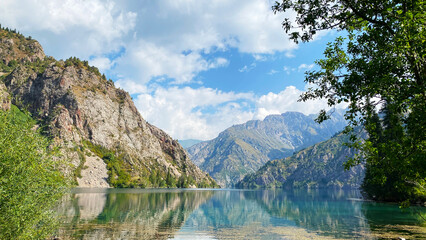 Fototapeta na wymiar Summer vacation in the mountains of Kyrgyzstan on the shore of the amazing lake Sary Chelek. The State Biosphere Reserve is a specially protected natural territory of Kyrgyzstan.