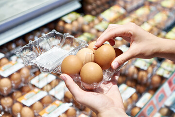 Woman with packing eggs in shop