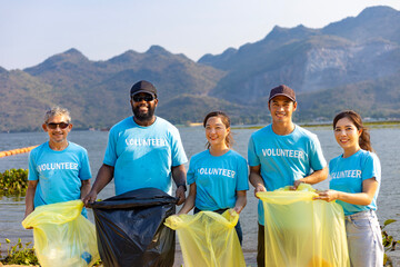 Team of young and diversity volunteer worker group enjoy charitable social work outdoor in cleaning...