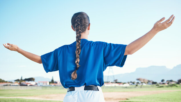 Woman, arms raised and winner with cheers, softball and sports with athlete on outdoor pitch and back view. Pray, hope and freedom, celebration and exercise, baseball player and winning competition
