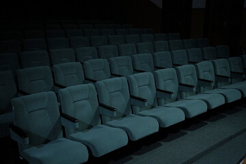 Soft classic empty armchairs arranged in straight, even parallel rows. Armchairs in the auditorium for conferences. Armchairs in the theater, in the cinema.