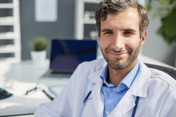 A male doctor in a white coat looks at the medical history and laughs.